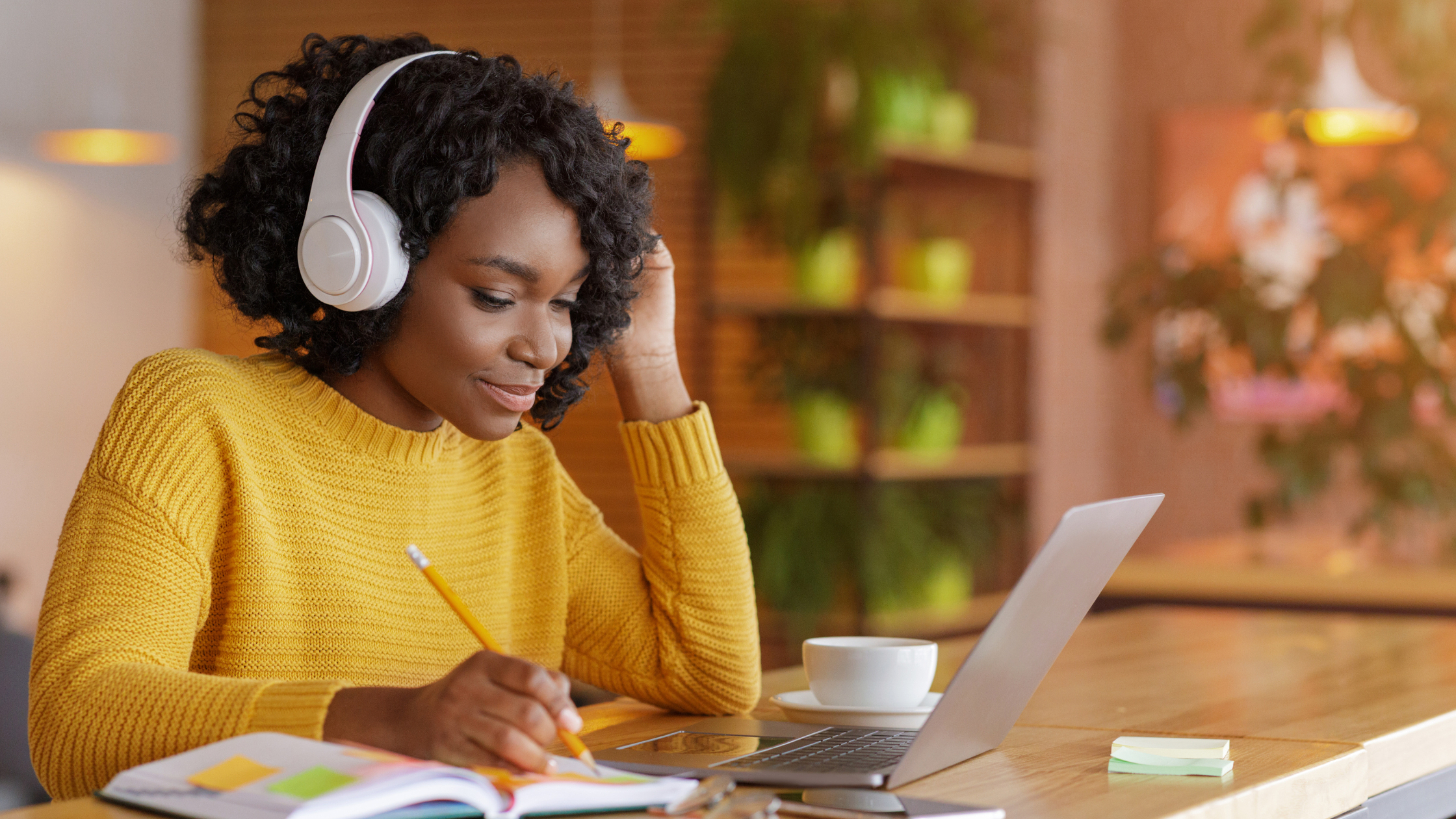Woman studying and listening to lectures on laptop, preparing for AIP Certified Coach training